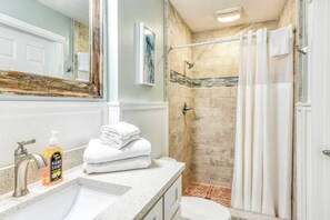 Een douche, handdoeken, shampoo, toiletpapier