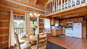 A wooden cabin with a dining area, kitchen, and a balcony. - Super View,Smoky Mtn Log Cabin,Pool Table,Hot Tub (Sevierville)