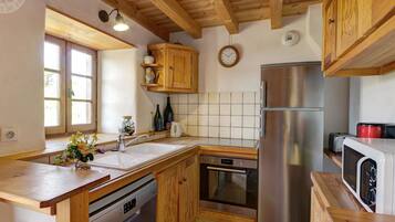 Une cuisine avec des meubles en bois, un réfrigérateur en acier inoxydable, un lave-vaisselle et un four à micro-ondes.