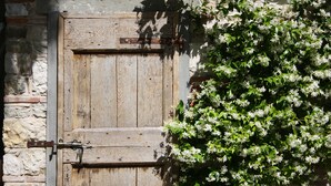 A rustic wooden door with a metal latch, set against a stone wall. - Spacious home on beautiful Tuscan vineyard.  Near Florence. (Pelago)