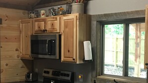 A kitchen with wooden cabinets, a microwave, a stove, a sink, and a window. - #4 Fall Creek Cabins family friendly 1 mile from Lake Norfork , Mtn. Home Ar. (Mountain Home)
