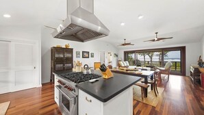 Een moderne keuken met een centraal eiland, een ingebouwde oven en een grote afzuigkap.