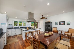 Enjoy meals in the kitchen with a central island and bar stools, featuring a range, microwave, and sink.