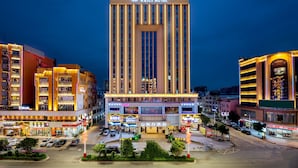 Un hotel con un diseño vertical llamativo, varios pisos y una fachada bien iluminada.