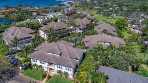 An aerial view of a coastal residential area with houses, a beach, and a clear sky. - 3BR/3BA Villa, Central A/C, Resort Style Complex, 5 Minute Walk To Poipu Beach! (Koloa)