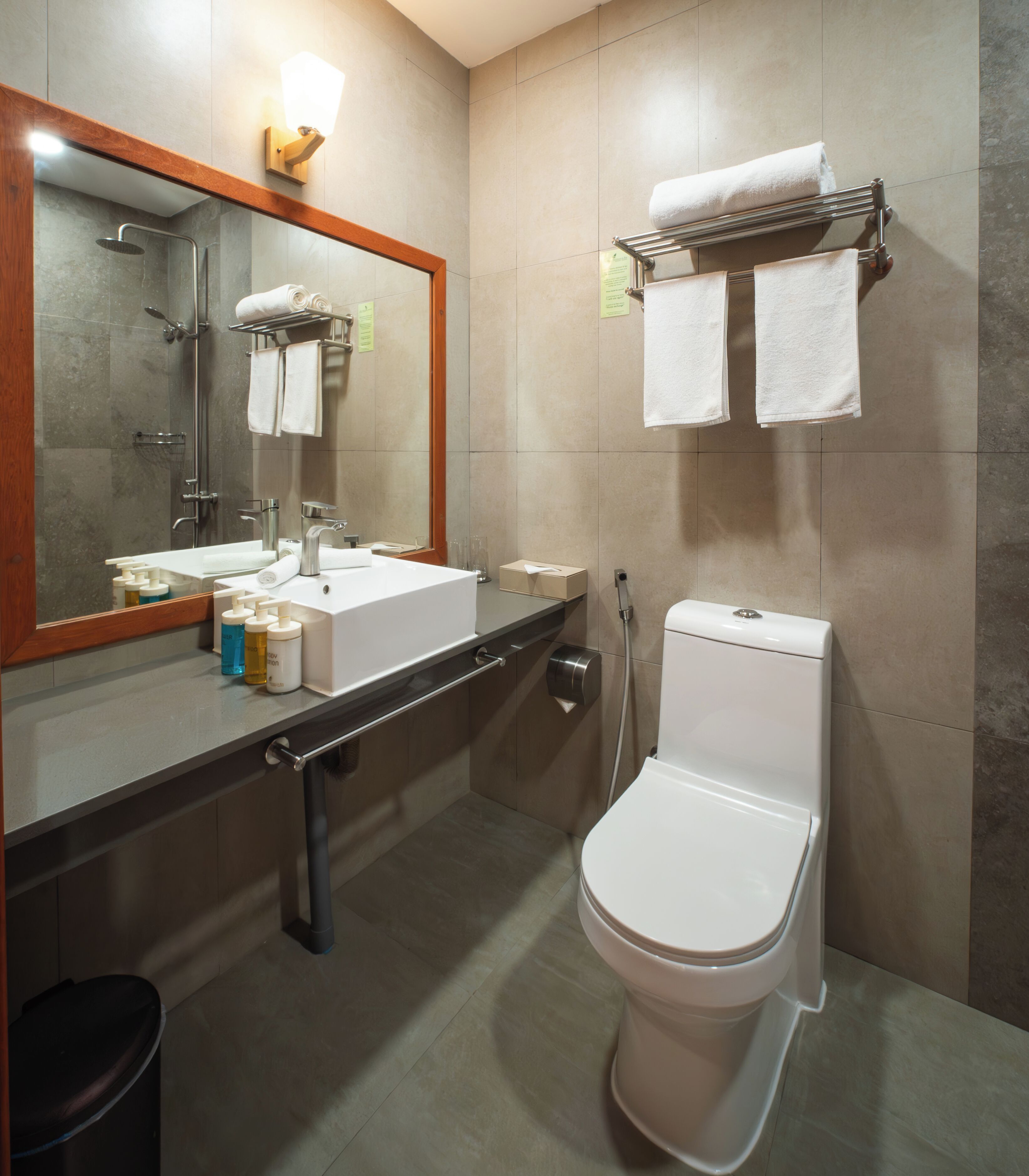 Un bagno moderno con lavandino, specchio, asciugamano e water.