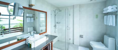 A modern bathroom with a large mirror, a sink, a shower, and a toilet.