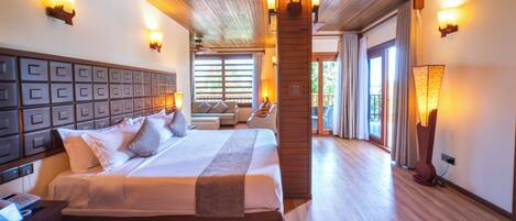 Una habitación de hotel espaciosa con una cama grande, techo de madera y múltiples apliques.