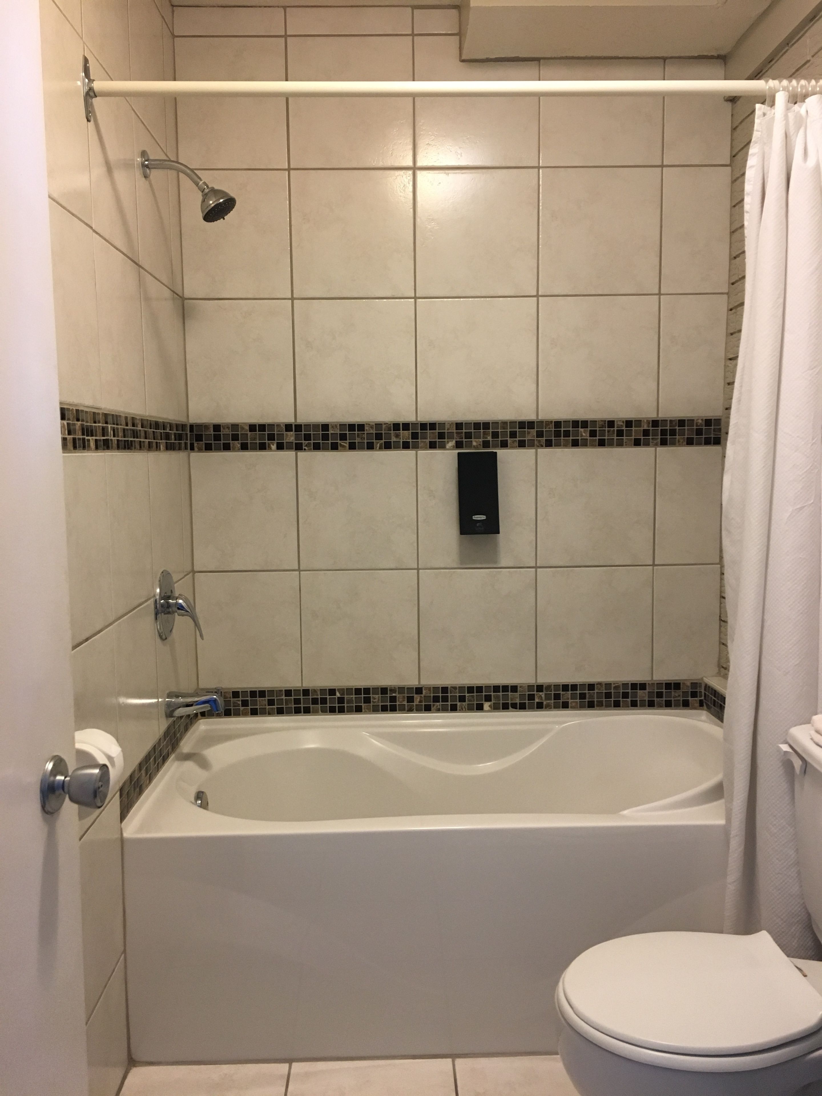 Un baño con bañera, inodoro y ducha.