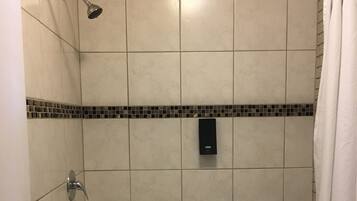 Un baño con bañera, inodoro y ducha.