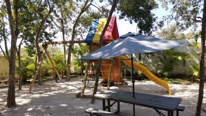 A playground with swings, slides, and a picnic table.