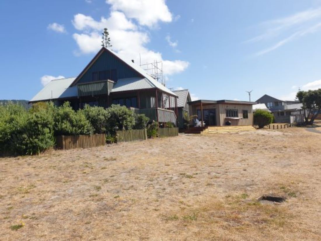A residential area with houses, a grassy field, and a clear sky.