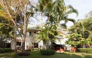A resort with a pool, palm trees, and a building with a sloped roof. - Garden Room by quiet tropical flora and patios (Hang Dong)