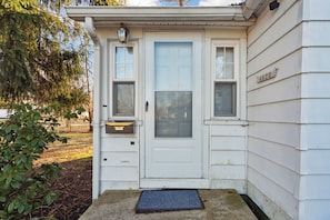 Welcome to a charming residence with a front door featuring a glass panel and a small window.