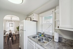 Enjoy cooking in this well-lit kitchen with a double sink, refrigerator, and granite countertop.