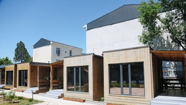 A row of modern, wooden-framed buildings with large windows and a flat roof. - Apple Hostel (Bishkek)
