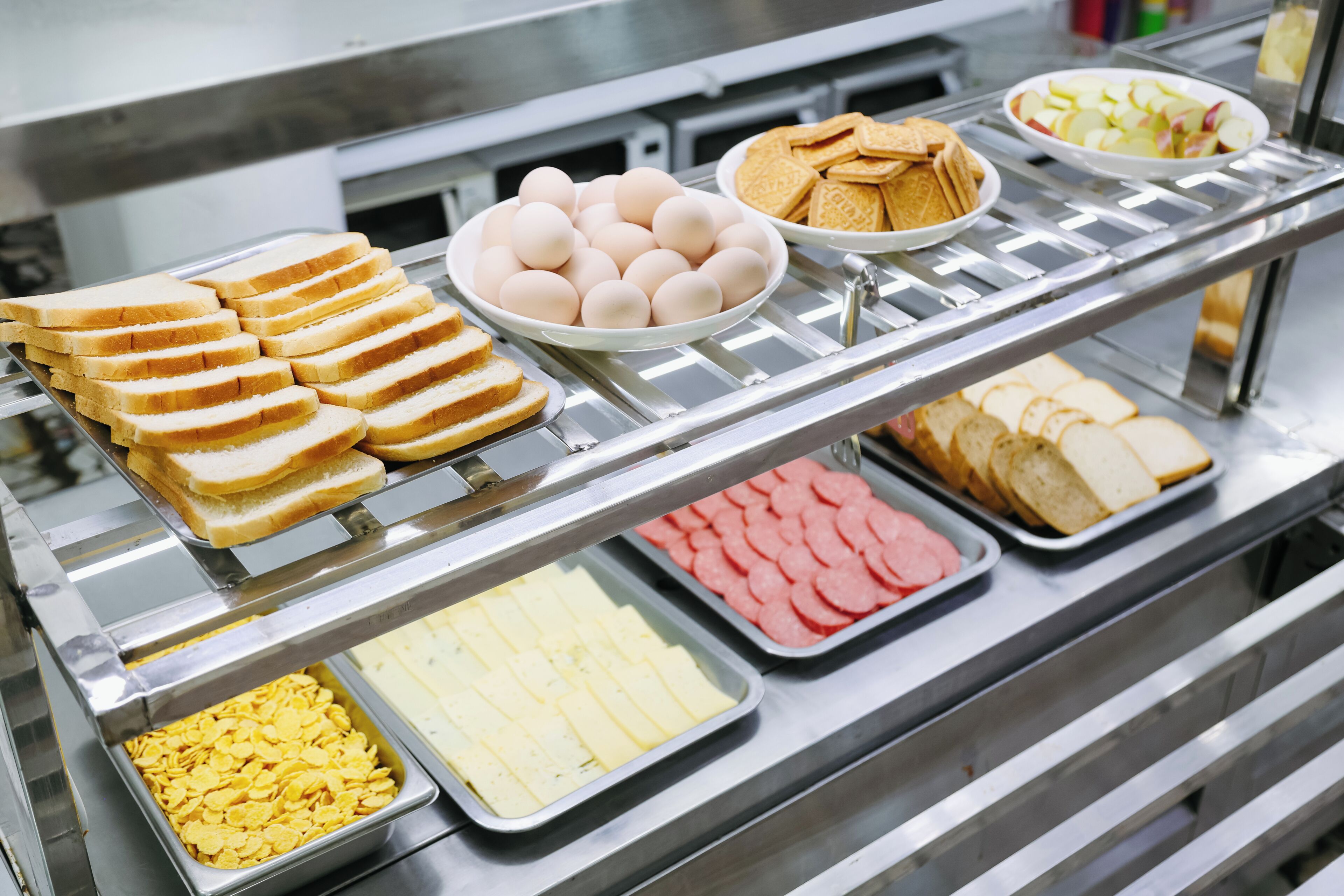 A buffet with various food items including bread, eggs, crackers, and sliced meats.