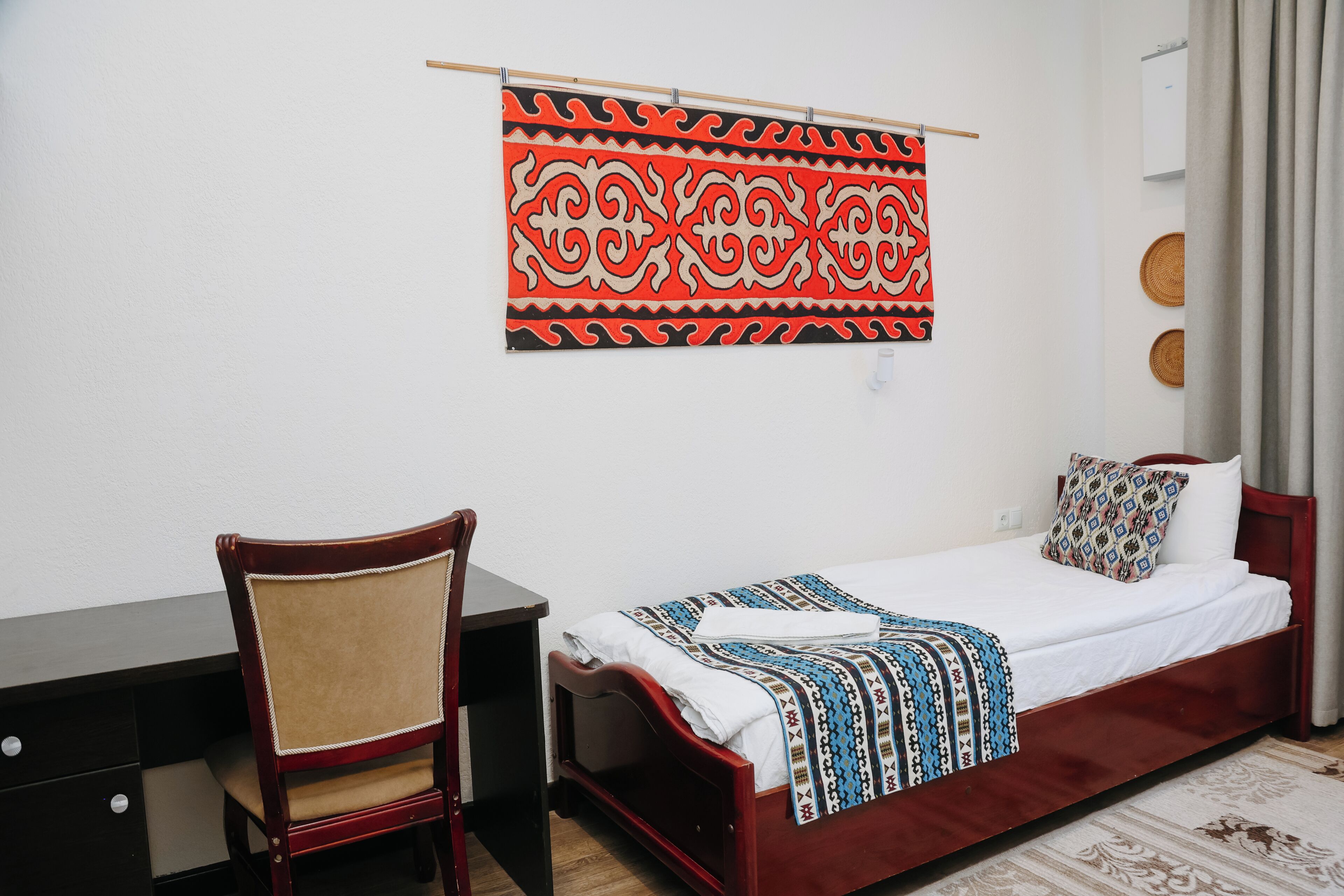 Een kamer met een bed, een bureau en een stoel.
