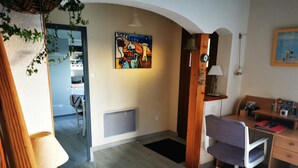 Een kamer met een bureau, stoel en een schilderij aan de muur.