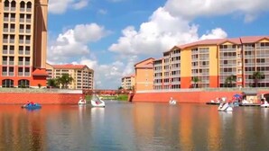 Een hotel aan het water met meerdere gebouwen, een rustige rivier en verschillende boten.