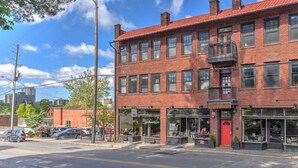 A two-story brick building with storefronts on the ground floor, including a bakery and a restaurant. - Charming Historic Condo (Asheville)
