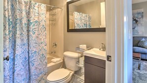 Et badeværelse med brusebad, toilet og håndvask.