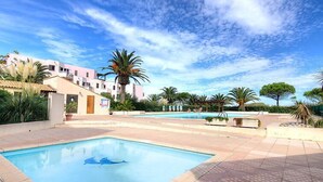 A swimming pool with a dolphin design, surrounded by palm trees and a clear blue sky. - Les Capitelles by Interhome (Saint Cyprien)