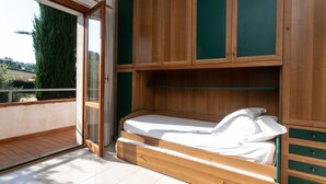 A room with a bed, wooden cabinets, and a sliding glass door to a balcony. - M148 - Marcelli, delightful villa with garden (Marcelli)