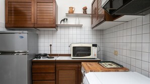 A kitchen with wooden cabinets, a microwave, a refrigerator, and a wooden cutting board. - M148 - Marcelli, delightful villa with garden (Marcelli)