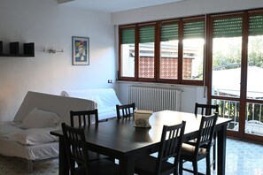 Une pièce comprenant un lit, une table à manger avec des chaises, un radiateur et une fenêtre donnant sur l’extérieur.