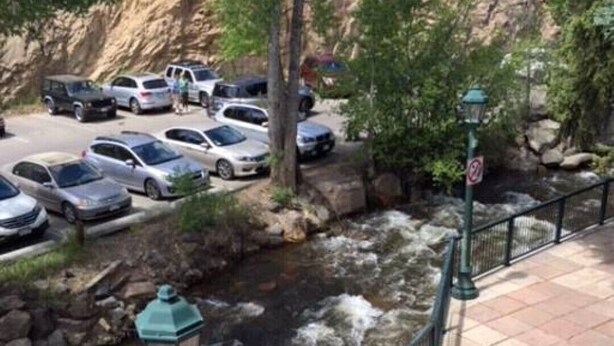 Un río con barandilla y un área de estacionamiento con automóviles.
