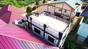 Un bâtiment doté d’un toit plat et d’un balcon sur lequel est affiché un panneau indiquant : « BIENVENUE À GYASON ».