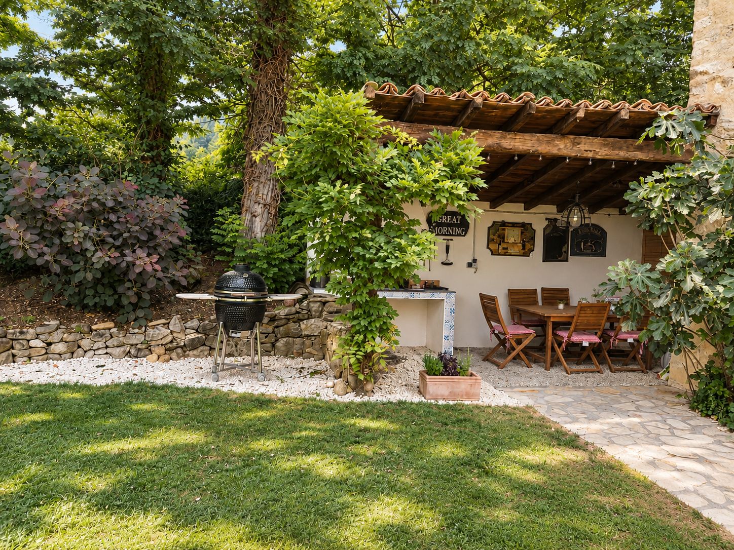 Un patio con pared de piedra, una parrilla y una mesa con sillas.