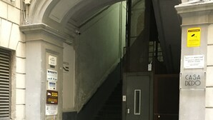 An entrance to a building with a staircase leading inside. There are signs on the walls indicating the location and possibly the name of the building. - B&B Binario 39 (Naples)