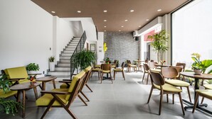 Een modern interieur met een trap, zithoeken en potplanten.
