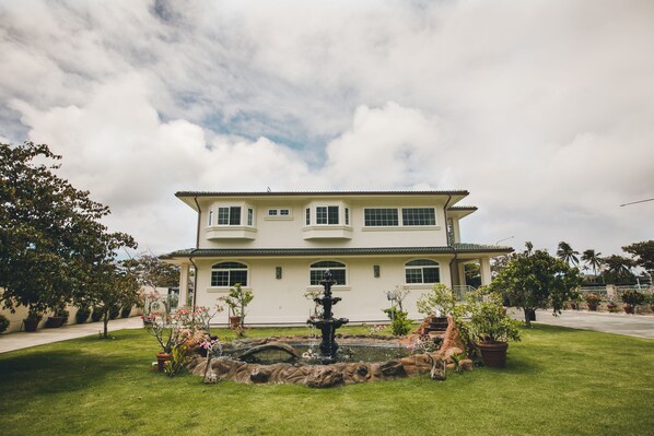 A two-story building with a fountain in the front yard. - Home of Aloha, 5 Bedrooms / 4 Baths, Sleeps 14 (Honolulu)