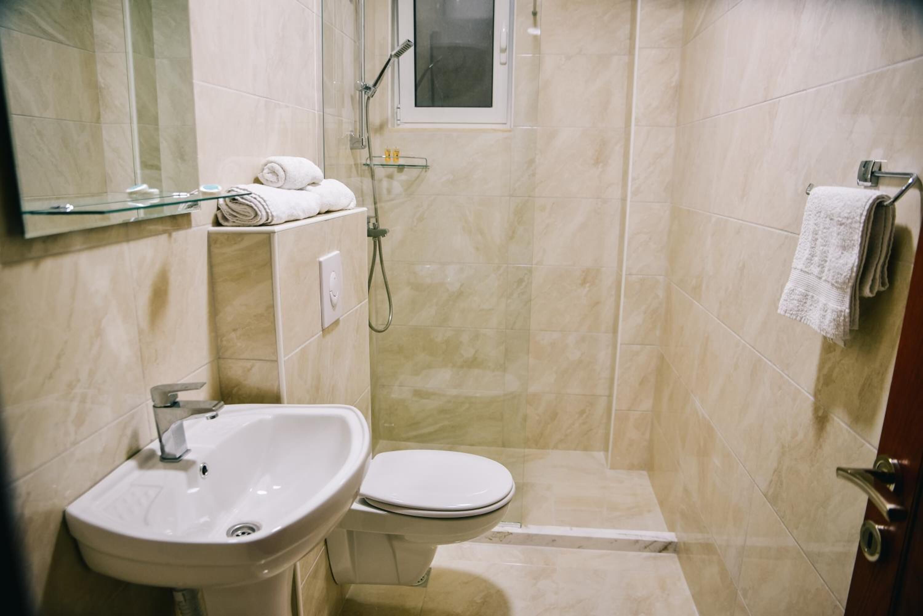 A bathroom with a sink, toilet, and shower.