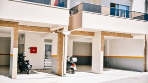 Un parking où deux motos sont stationnées sous un abri.