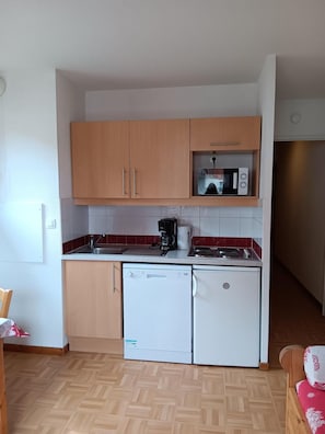 A compact kitchen with wooden cabinets, a microwave, a coffee maker, and a dishwasher. - Wifi, 3rd floor, swimming pool, balcony, parking, tv, ski locker, 25m², Puy-Saint-Vincent (Puy-Saint-Vincent)