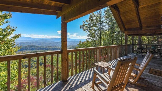 A wooden deck with a view of mountains and trees. - View! Private Studio Cabin,Hot Tub,RELAX,Honeymoon (Sevierville)