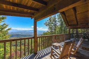 Eine Holzterrasse mit Blick auf Berge und Bäume.