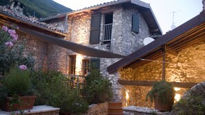 Une maison en pierre avec un escalier en bois menant à un deuxième étage.