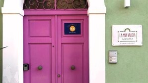 A purple double door with a sign above it and a sign on the wall to the right.
