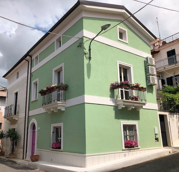 A two-story building with balconies, white trim, and flower boxes. - B&B La Mia Valigia (San Lucido)
