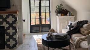 A cozy living room with a fireplace, a black coffee table, and a sofa. - THE BARN ON PASCAL... A lovely circa 1900 refurbished barn. (Rockport)
