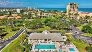 A resort with a swimming pool, a covered patio, and a view of the ocean. - Luxurious Beach Resort Atmosphere Getaway (Fort pierce)