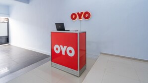 A red OYO branded reception desk with a laptop in a modern, minimalistic lobby. - OYO 672 Bali Radiance Canggu (Tibubeneng)