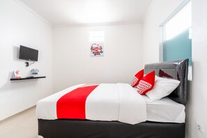 Une chambre moderne avec un lit, un téléviseur à écran plat, une petite étagère contenant des articles de toilette et un tableau encadré au mur.