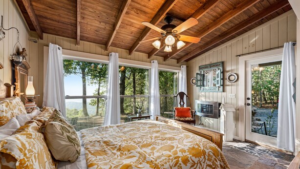A bedroom with a large bed, wooden ceiling, and a view of the outdoors. - Amazing Mountain Views Special Rates Book Today (Mentone)