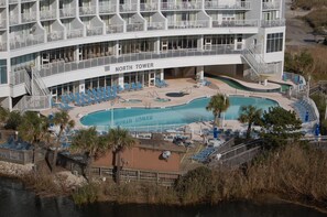 A multi-story hotel with a pool area, sun loungers, and a sign reading "NORTH TOWER".